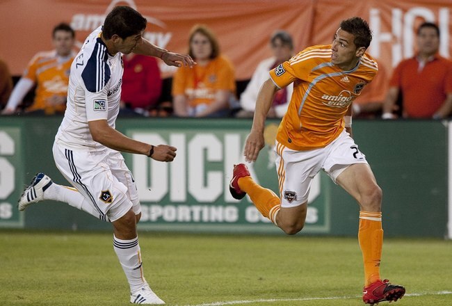 HOUSTON - APRIL 10:  Geoff Cameron #20 of the Houston Dynamo slips behind Omar Gonzalez #4 of the L.A. Galaxy April 10, 2010 in Houston, Texas.  (Photo by Bob Levey/Getty Images)