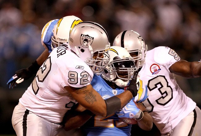 OAKLAND, CA - SEPTEMBER 14:  LaDainian Tomlinson #21 of the San Diego Chargers is tackled by Richard Seymour #92 of the Oakland Raiders during their game on September 14, 2009 at the Oakland-Alameda County Coliseum in Oakland, California.  (Photo by Ezra Shaw/Getty Images)