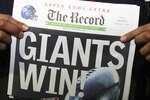 GLENDALE, AZ - FEBRUARY 03:  Defensive end Michael Strahan #92 of the New York Giants holds a copy of the Bergen Record with the headline 'GIANTS WIN!' after the Giants defeated the New England Patriots 17-14 during Super Bowl XLII on February 3, 2008 at the University of Phoenix Stadium in Glendale, Arizona.  (Photo by Donald Miralle/Getty Images)