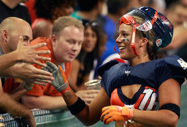 HOFFMAN ESTATES, IL - SEPTEMBER 04:  Kate Johns of the Chicago Bliss greets fans following the Bliss' defeat of the Miami Caliente during the opening game of the Lingerie Football League (LFL) at the Sears Centre Arena September 4, 2009 in Hoffman Estates, Illinois. The LFL is a female football league with ten teams that compete in seven-on-seven full-contact American football, with players dressed in sports bras and short shorts.  (Photo by Scott Olson/Getty Images)
