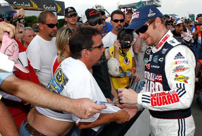 LONG POND, PA - JUNE 04:  Dale Earnhardt Jr. (R), driver of the #88 National Guard/AMP Energy Chevrolet, signs memorabilia in the garage area during qualifying for the NASCAR Sprint Cup Series Gillette Fusion ProGlide 500 at Pocono Raceway on June 4, 2010 in Long Pond, Pennsylvania.  (Photo by Sam Greenwood/Getty Images)