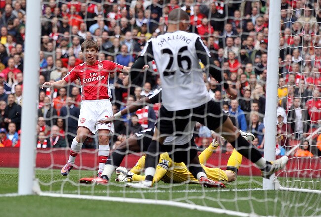 LONDON, ENGLAND - MAY 09:  Andre Arshavin of Arsenal threads the ball past Mark Schwarzer of Fulham and Chris Smalling of Fulham (26) to score Arsenal's first goal during the Barclays Premier League match between Arsenal and Fulham at The Emirates Stadium on May 9, 2010 in London, England.  (Photo by David Cannon/Getty Images)