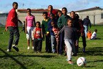 CAPE TOWN, SOUTH AFRICA - JUNE 09:  A young boy kicks a ball during a school coaching clinic in Fisantekrall township on June 9, 2010 in Cape Town, South Africa.  (Photo by Lars Baron/Getty Images)
