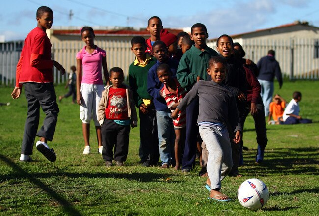 CAPE TOWN, SOUTH AFRICA - JUNE 09:  A young boy kicks a ball during a school coaching clinic in Fisantekrall township on June 9, 2010 in Cape Town, South Africa.  (Photo by Lars Baron/Getty Images)