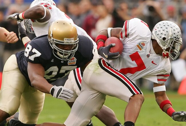 TEMPE, AZ - JANUARY 02:  Wire receiver/kick returner Ted Ginn Jr. #7 of the Ohio State Buckeyes looks to break a tackle by Marcus Freeman #87 of the Notre Dame Fighting Irish in the Tostito's Fiesta Bowl at Sun Devil Stadium on January 2, 2006 in Tempe, Arizona. The Buckeyes defeated the Fighting Irish 34-20.  (Photo by Lisa Blumenfeld/Getty Images)