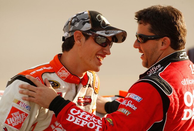 RICHMOND, VA - SEPTEMBER 11:  Joey Logano, driver of the #20 Home Depot Toyota, stands on pit road with Tony Stewart, driver of the #14 Office Depot Chevrolet, during qualifying for the NASCAR Sprint Cup Series Chevy Rock & Roll 400 at Richmond International Raceway on September 11, 2009 in Richmond, Virginia.  (Photo by Chris Graythen/Getty Images)