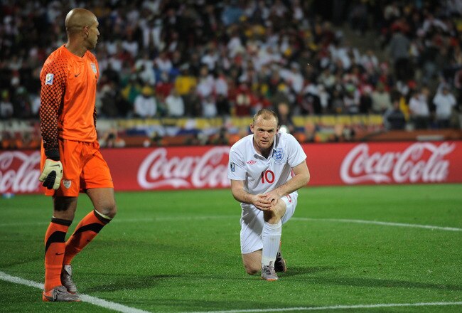 RUSTENBURG, SOUTH AFRICA - JUNE 12: Wayne Rooney of England picks himself up as Tim Howard of the United States looks on during the 2010 FIFA World Cup South Africa Group C match between England and USA at the Royal Bafokeng Stadium on June 12, 2010 in Rustenburg, South Africa.  (Photo by Michael Regan/Getty Images)