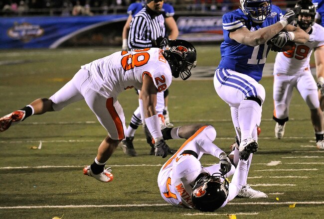 LAS VEGAS - DECEMBER 22:  Manase Tonga #11 of the Brigham Young University Cougars gets by Suaesi Tuimaunei #28 and Anthony Watkins #47 of the Oregon State Beavers en route to scoring a touchdown in the fourth quarter of the MAACO Las Vegas Bowl at Sam Boyd Stadium December 22, 2009 in Las Vegas, Nevada. The Cougars won 44-20.  (Photo by Ethan Miller/Getty Images)