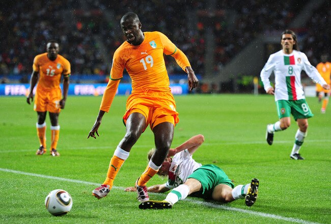 PORT ELIZABETH, SOUTH AFRICA - JUNE 15:  Yaya Toure of Ivory Coast is tackled by Fabio Coentrao of Portugal during the 2010 FIFA World Cup South Africa Group G match between Ivory Coast and Portugal at Nelson Mandela Bay Stadium on June 15, 2010 in Port Elizabeth, South Africa.  (Photo by Jamie McDonald/Getty Images)