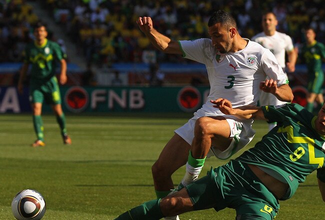 POLOKWANE, SOUTH AFRICA - JUNE 13:  Nadir Belhadj of Algeria is tackled by Zlatan Ljubijankic of Slovenia during the 2010 FIFA World Cup South Africa Group C match between Algeria and Slovenia at the Peter Mokaba Stadium on June 13, 2010 in Polokwane, South Africa.  (Photo by Cameron Spencer/Getty Images)
