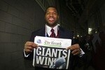 GLENDALE, AZ - FEBRUARY 03:  Defensive end Michael Strahan #92 of the New York Giants holds a copy of the Bergen Record with the headline 'GIANTS WIN!' after the Giants defeated the New England Patriots 17-14 during Super Bowl XLII on February 3, 2008 at the University of Phoenix Stadium in Glendale, Arizona.  (Photo by Donald Miralle/Getty Images)
