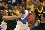 SYRACUSE, NY - MARCH 27:  John Wall #11 of the Kentucky Wildcats attempts to maintain control of the ball inthe first half against Kevin Jones #5 (L) and Devin Ebanks #3 of the West Virginia Mountaineers during the east regional final of the 2010 NCAA men's basketball tournament at the Carrier Dome on March 27, 2010 in Syracuse, New York.  (Photo by Jim McIsaac/Getty Images)
