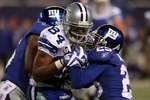 EAST RUTHERFORD, NJ - DECEMBER 06: Aaron Rouse #26 and Bruce Johnson #25 (R) of the New York Giants attempt to strip Patrick Crayton #84 of the Dallas Cowboys after Crayton made a reception in the fourth quarter at Giants Stadium on December 6, 2009 in East Rutherford, New Jersey. (Photo by Jim McIsaac/Getty Images)