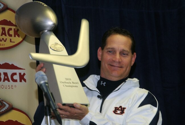 TAMPA, FL - JANUARY 1: Coach Gene Chizik of the Auburn Tigers holds the Outback trophy after an overtime victory against the Northwestern Wildcats in the Outback Bowl January 1, 2010 at Raymond James Stadium in Tampa, Florida.  (Photo by Al Messerschmidt/Getty Images)
