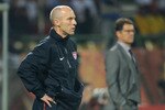 RUSTENBURG, SOUTH AFRICA - JUNE 12: Bob Bradley head coach of USA watches from the touchline in front of Fabio Capello manager of England during the 2010 FIFA World Cup South Africa Group C match between England and USA at the Royal Bafokeng Stadium on June 12, 2010 in Rustenburg, South Africa.  (Photo by Kevork Djansezian/Getty Images)