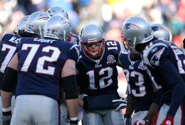 FOXBORO, MA - JANUARY 10:  Quarterback Tom Brady #12 of the New England Patriots calls a play in the huddle against the Baltimore Ravens during the 2010 AFC wild-card playoff game at Gillette Stadium on January 10, 2010 in Foxboro, Massachusetts.  (Photo by Jim Rogash/Getty Images)