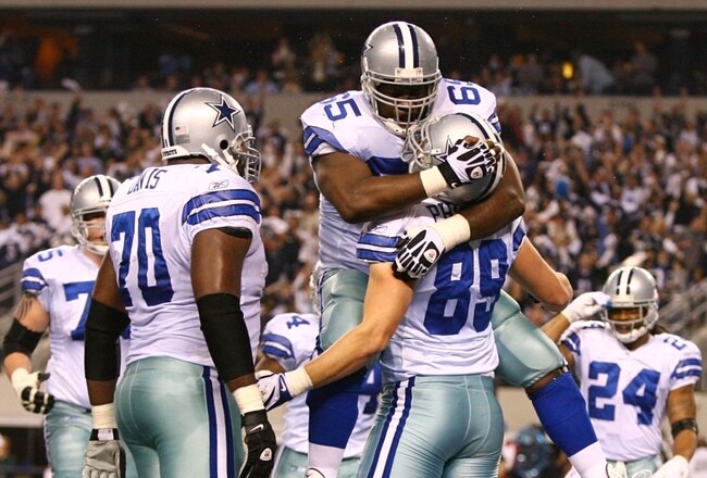 ARLINGTON, TX - JANUARY 9:  Andre Gurode #65 of the Dallas Cowboys jumps on John Phillips #89 after Phillips scores a one-yard touchdown in the second quarter against the Philadelphia Eagles during the 2010 NFC wild-card playoff game at Cowboys Stadium on January 9, 2010 in Arlington, Texas. (Photo by Jamie Squire/Getty Images)