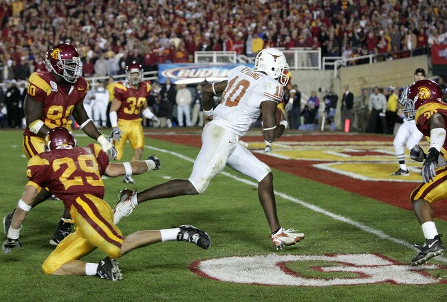 PASADENA, CA - JANUARY 04:  Vince Young #10 of the Texas Longhorns rushes past Frostee Rucker #90, Scott Ware #29 and Josh Pinkard #36 of the USC Trojans to score a 2 point conversion following his touchdown in the final moments of the BCS National Championship Rose Bowl Game at the Rose Bowl on January 4, 2006 in Pasadena, California.  Texas defeated USC 41-38.  (Photo by Harry How/Getty Images)