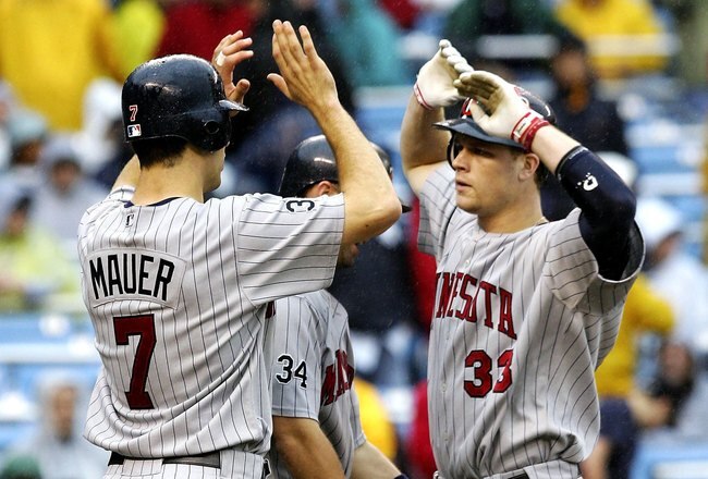 NEW YORK - SEPTEMBER 2:  Justin Morneau #33 of the Minnesota Twins is met at home by teammates Michael Cuddyer #5 and Joe Mauer #5 after hitting a three run home run in the eigth inning against the New York Yankees at Yankee Stadium September 2, 2006 in the Bronx borough of New York City. The Twins defeated the Yankees 6 to 1.  (Photo by Jim McIsaac/Getty Images)