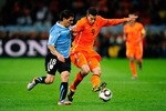 CAPE TOWN, SOUTH AFRICA - JULY 06: Robin Van Persie of the Netherlands is challenged by Maximiliano Pereira of Uruguay during the 2010 FIFA World Cup South Africa Semi Final match between Uruguay and the Netherlands at Green Point Stadium on July 6, 2010 in Cape Town, South Africa.  (Photo by Jamie McDonald/Getty Images)
