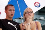 ARLINGTON, TX - SEPTEMBER 11:  As rain falls, fans sit under an umbrella before the start of the Seattle Mariners and the Texas Rangers on September 11, 2009 in Arlington, Texas.  (Photo by Ronald Martinez/Getty Images)