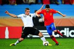 DURBAN, SOUTH AFRICA - JULY 07:  David Villa of Spain is tackled by Lukas Podolski of Germany during the 2010 FIFA World Cup South Africa Semi Final match between Germany and Spain at Durban Stadium on July 7, 2010 in Durban, South Africa.  (Photo by Clive Mason/Getty Images)