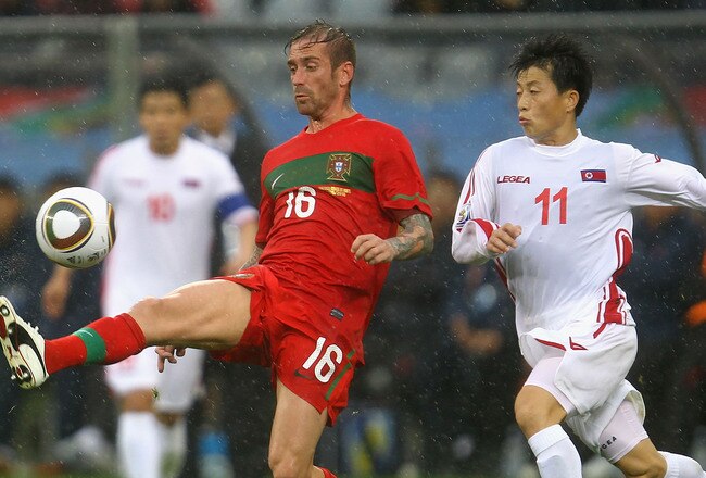 CAPE TOWN, SOUTH AFRICA - JUNE 21: Mun In-Guk of North Korea challenges Raul Meireles of Portugal during the 2010 FIFA World Cup South Africa Group G match between Portugal and North Korea at the Green Point Stadium on June 21, 2010 in Cape Town, South Africa.  (Photo by Lars Baron/Getty Images)