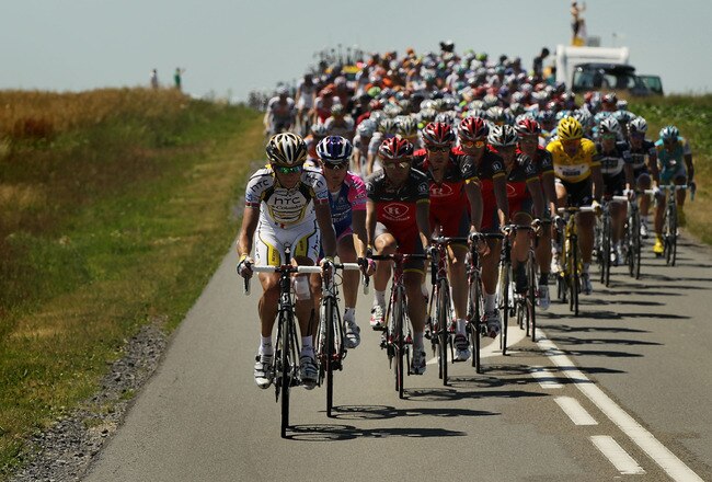 REIMS, FRANCE - JULY 07: The peloton passes along the 153.5km course in stage four of the Tour de France on July 7, 2010 in Reims, France. A relatively flat stage, the route featured only one category four climb. Italian Alessandro Petacchi with the Lampre team won the stage in a sprint finish. Swiss rider Fabian Cancellara of team Saxo Bank has kept hold of the yellow jersey while Lance Armstrong sits in 18th place overall. The iconic bicycle race will include a total of 20 stages and will cover 3,642km before concluding in Paris on July 25.  (Photo by Spencer Platt/Getty Images)