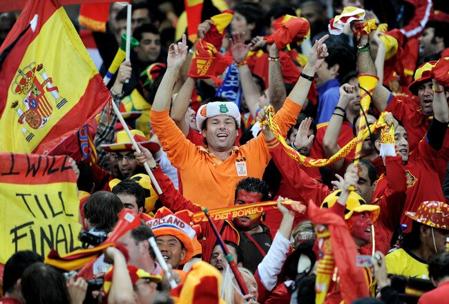 DURBAN, SOUTH AFRICA - JULY 07:  A Netherlands fan celebrates with Spain fans after their victory and progress to the final during the 2010 FIFA World Cup South Africa Semi Final match between Germany and Spain at Durban Stadium on July 7, 2010 in Durban, South Africa.  (Photo by Jasper Juinen/Getty Images)