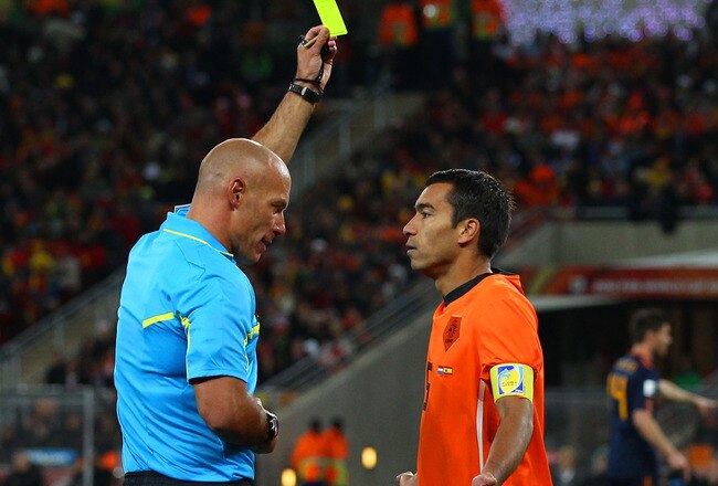 JOHANNESBURG, SOUTH AFRICA - JULY 11:  Referee Howard Webb issues Giovanni Van Bronckhorst of the Netherlands a yellow card during the 2010 FIFA World Cup South Africa Final match between Netherlands and Spain at Soccer City Stadium on July 11, 2010 in Johannesburg, South Africa.  (Photo by Clive Rose/Getty Images)