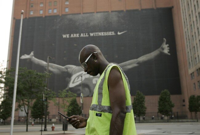 CLEVELAND - JULY 8:  A parking attendant stands near a larger than life photograph of LeBron James July 8, 2010 in Cleveland, Ohio. The two-time Most Valuable Player has the choice of remaining with the Cleveland Cavaliers or signing with a new team. (Photo by J.D. Pooley/Getty Images)