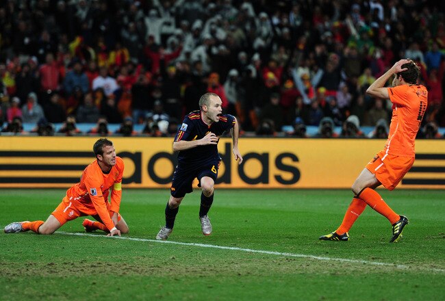 JOHANNESBURG, SOUTH AFRICA - JULY 11:  Andres Iniesta of Spain (C) celebrates scoring the winning goal as Joris Mathijsen (R) and Rafael Van der Vaart of the Netherlands look on dejected during the 2010 FIFA World Cup South Africa Final match between Netherlands and Spain at Soccer City Stadium on July 11, 2010 in Johannesburg, South Africa.  (Photo by Jamie McDonald/Getty Images)