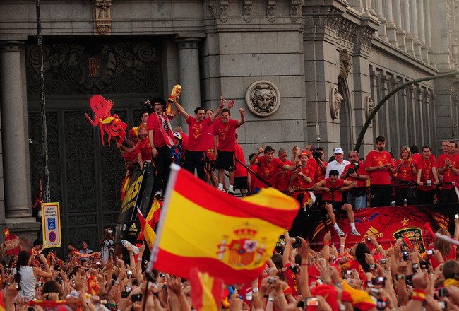 MADRID, SPAIN - JULY 12:  Xavi Hernandez holds aloft the FIFA World Cup trophy to the crowd gathered in Plaza Cibeles on July 12, 2010 in Madrid, Spain.  (Photo by Denis Doyle/Getty Images)