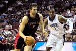 ORLANDO, FL - DECEMBER 16:  Andrea Bargnani #7 of the Toronto Raptors drives past Dwight Howard #12 of the Orlando Magic during the game at Amway Arena on December 16, 2009 in Orlando, Florida.  NOTE TO USER: User expressly acknowledges and agrees that, by downloading and/or using this Photograph, user is consenting to the terms and conditions of the Getty Images License Agreement.  (Photo by Sam Greenwood/Getty Images)