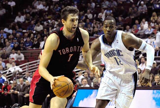 ORLANDO, FL - DECEMBER 16:  Andrea Bargnani #7 of the Toronto Raptors drives past Dwight Howard #12 of the Orlando Magic during the game at Amway Arena on December 16, 2009 in Orlando, Florida.  NOTE TO USER: User expressly acknowledges and agrees that, by downloading and/or using this Photograph, user is consenting to the terms and conditions of the Getty Images License Agreement.  (Photo by Sam Greenwood/Getty Images)