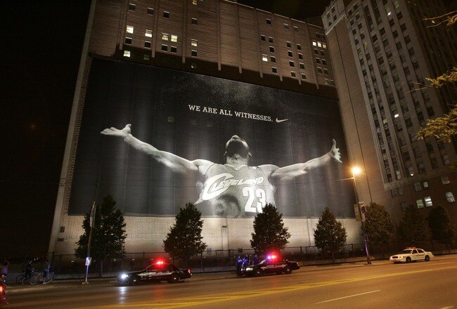 CLEVELAND - JULY 8:  Police stand guard near a larger than life photograph of LeBron James after the announcement that James will play next season for the Miami Heat July 8, 2010 in Cleveland, Ohio. The two-time Most Valuable Player made the choice to play for Miami next season. (Photo by J.D. Pooley/Getty Images)