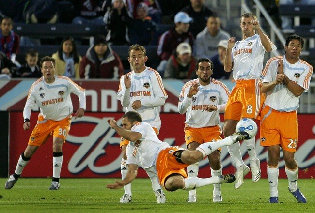 COMMERCE CITY, CO - MAY 05:  Brian Mullan #9 of the Houston Dynamo takes the front line of defense against a free kick by Greg Vanney #3 of the Colorado Rapids at Dick's Sporting Goods Park on May 5, 2007 in Commerce City, Colorado. Richard Mulrooney #30, Brad Davis #11, Dwayne De Rosario #14, Paul Dalglish #8 and Brain Ching #25 complete the line of defense for the Dynamos.  (Photo by Doug Pensinger/Getty Images)