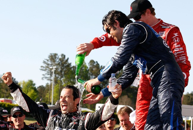 LEEDS, AL - APRIL 11:  Race winner Helio Castroneves of Brazil, driver of the #3 Team Penske Dallara Honda celebrates has champagne poured on him by Scott Dixon and Dario Franchitti of Chip Ganassi racing after winning the IRL IndyCar Series Grand Prix of Alabama at Barber Motorsports Park on April 11, 2010 in Leeds, Alabama.  (Photo by Chris Graythen/Getty Images)