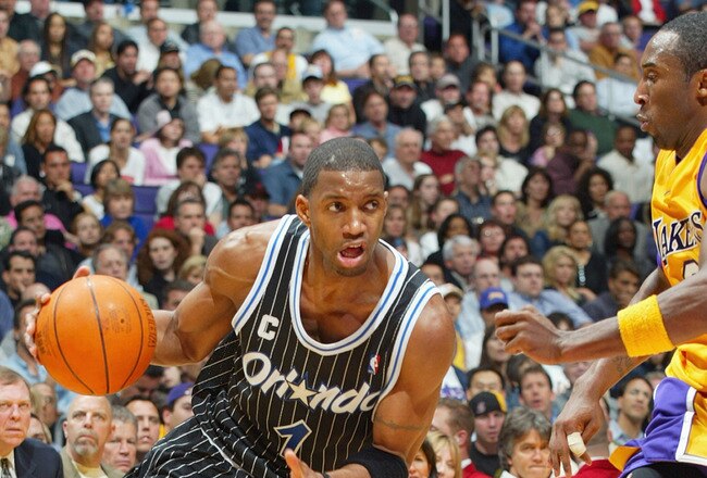 LOS ANGELES - MARCH 15:  Tracy McGrady #1  of the Orlando Magic drives past Kobe Bryant #8 of the Los Angeles Lakers during the game at Staples Center on March 15, 2004 in Los Angeles, California.  The Lakers won 113-110.   NOTE TO USER: User expressly acknowledges and agrees that, by downloading and/or using this Photograph, User is consenting to the terms and conditions of the Getty Images License Agreement.  (Photo by Lisa Blumenfeld/Getty Images)