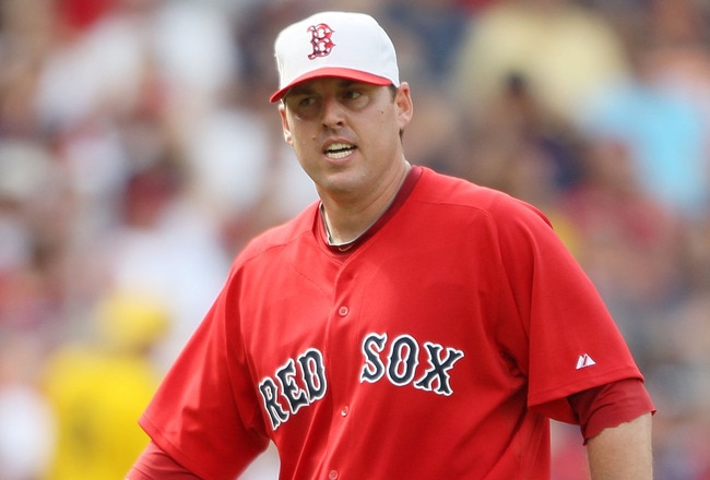 BOSTON - JULY 04:  John Lackey #40 of the Boston Red Sox reacts after Ty Wigginton of the Baltimore Orioles makes it safely to first base on July 4, 2010 at Fenway Park in Boston, Massachusetts.  (Photo by Elsa/Getty Images)