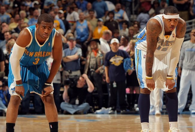 DENVER - APRIL 22:  Chris Paul #3 of the New Orleans Hornets and Carmelo Anthony #15 of the Denver Nuggets await action in Game Two of the Western Conference Quarterfinals during the 2009 NBA Playoffs at Pepsi Center on April 22, 2009 in Denver, Colorado. The Nuggets defeated the Hornets 108-93. NOTE TO USER: User expressly acknowledges and agrees that, by downloading and or using this photograph, User is consenting to the terms and conditions of the Getty Images License Agreement.  (Photo by Doug Pensinger/Getty Images)