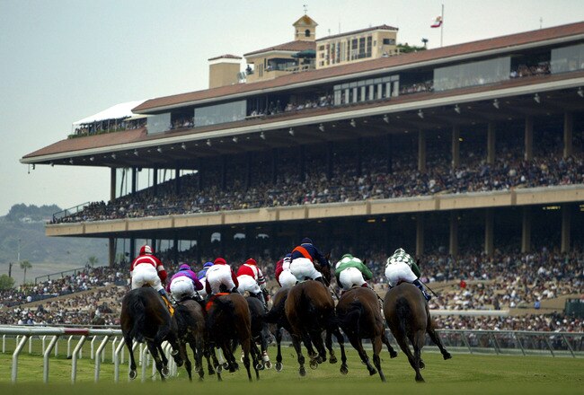 DEL MAR, CA - JULY 20:  A general view of the pack coming out of turn four into the front stretch with the grandstands in the background during Opening Day at the Del Mar Thoroughbred Club on July 20, 2005 in Del Mar, California.  (Photo by Donald Miralle/Getty Images)