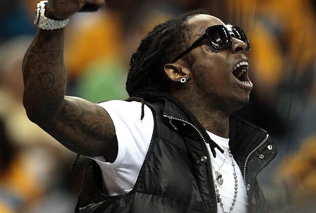 NEW ORLEANS - APRIL 25:  Rapper Lil Wayne has words with Carmelo Anthony of the Denver Nuggets during Game Three of the Western Conference Quarterfinals against the New Orleans Hornets during the 2009 NBA Playoffs at New Orleans Arena on April 25, 2009 in New Orleans, Louisiana. The Hornets won 95-93.  NOTE TO USER: User expressly acknowledges and agrees that, by downloading and or using this photograph, User is consenting to the terms and conditions of the Getty Images License Agreement.  (Photo by Bob Levey/Getty Images)