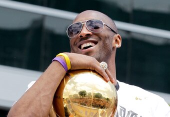 LOS ANGELES, CA - JUNE 21:  Los Angeles Lakers guard Kobe Bryant laughs with the championship trophy while riding in the victory parade for the the NBA basketball champion team on June 21, 2010 in Los Angeles, California. The Lakers beat the Boston Celtics 87-79 in 7 games for the franchise's 16 NBA title.  (Photo by Noel Vasquez/Getty Images)