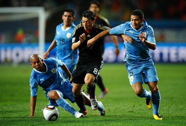 PORT ELIZABETH, SOUTH AFRICA - JULY 10: Mesut Oezil of Germany is challenged by Walter Gargano of Uruguay during the 2010 FIFA World Cup South Africa Third Place Play-off match between Uruguay and Germany at The Nelson Mandela Bay Stadium on July 10, 2010 in Port Elizabeth, South Africa.  (Photo by Laurence Griffiths/Getty Images)