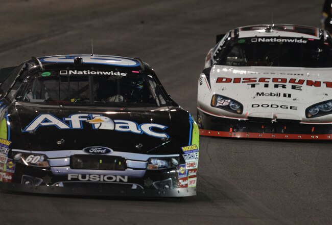 MADISON, IL - JULY 17: Carl Edwards, driver of the #60 Aflac Ford, leads Brad Keselowski driver of the #22 Discount Tire Dodge into turn three during the NASCAR Nationwide Series Missouri-Illinois Dodge Dealers 250 at Gateway International Raceway on July 17, 2010 in Madison, Illinois.  (Photo by Dilip Vishwanat/Getty Images for NASCAR)
