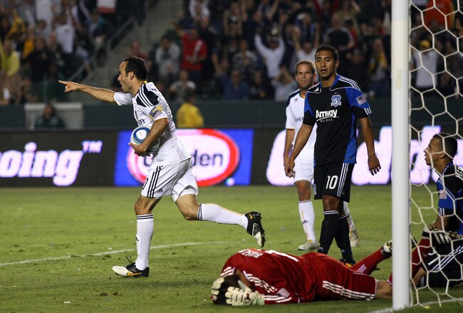 CARSON, CA - JULY 22:  Landon Donovan #10 of the Los Angeles Galaxy points to a teammate at midfield in celebration after scoring the equalizing goal in the second half as Arturo Alvarez #10 of the San Jose Earthquakes looks to fallen teammate goalkeeper Jon Busch #18 during their MLS match at The Home Depot Center on July 22, 2010 in Carson, California. The Earthquakes and the Galaxy played to a 2-2 draw. (Photo by Victor Decolongon/Getty Images)