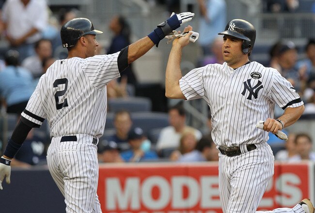 NEW YORK - JULY 22:  Derek Jeter #2 of the New York Yankees celebrates scoring with teammate Mark Teixeira #25 on an Alex Rodriguez #13 double in the first against the Kansas City Royals at Yankee Stadium on July 22, 2010 in the Bronx borough of New York City.  (Photo by Nick Laham/Getty Images)