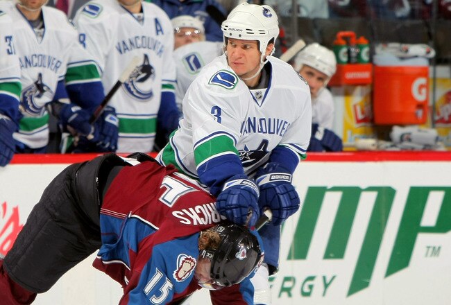 DENVER - OCTOBER 03:  Kevin Bieska #3 of the Vancouver Canucks delivers a hit to Matt Hendricks #15 of the Colorado Avalanche during NHL action at the Pepsi Center on October 3, 2009 in Denver, Colorado.  (Photo by Doug Pensinger/Getty Images)