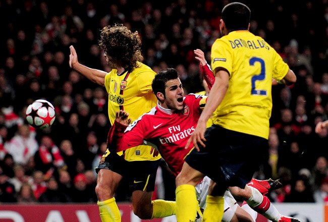 LONDON, ENGLAND - MARCH 31:  Cesc Fabregas of Arsenal is brought down by Carles Puyol (L) of Barcelona to win a penalty for his team during the UEFA Champions League quarter final first leg match between Arsenal and FC Barcelona at the Emirates Stadium on March 31, 2010 in London, England. Fabregas converted the penalty for Arsenal to level the scores at 2-2, while Carles Puyol of Barcelona was shown a red card. (Photo by Shaun Botterill/Getty Images)